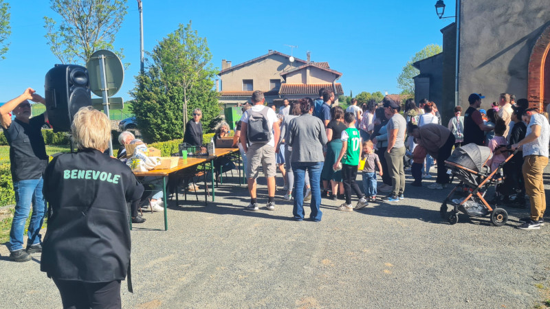 Une foule de parents près d'une table pour les inscriptions et un bénévole de dos
